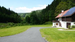 une maison avec une route à côté d'une pelouse dans l'établissement Ferienhaus Holzer, à Mönichwald