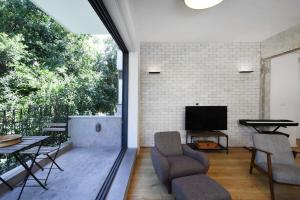 a living room with a tv and a table and chairs at Design 2BR in Dizengoff st by HolyGuest in Tel Aviv