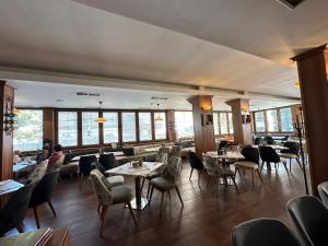 a restaurant with tables and chairs and windows at Hotel Cosmos in Ruse