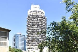 a tall building in front of two tall buildings at Design 2BR in Dizengoff st by HolyGuest in Tel Aviv