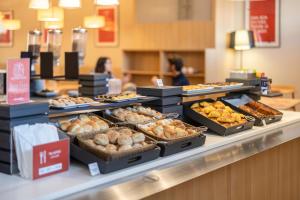 a bakery counter with many different types of pastries at Moov Hotel Porto Centro in Porto