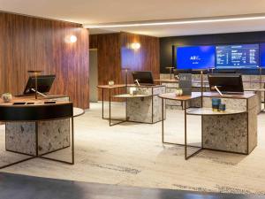 a lobby with several tables with laptops on them at Pullman Paris Montparnasse in Paris