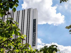 ein hohes Gebäude mit einem Schild an der Seite in der Unterkunft Pullman Paris Montparnasse in Paris