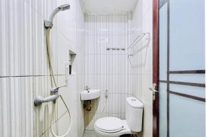 a bathroom with a toilet and a shower at RedDoorz @ Best Hotel Jalan Dr. Sutomo Siantar in Pematangsiantar