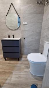 a bathroom with a sink and a toilet and a mirror at Carmela estudio in Málaga