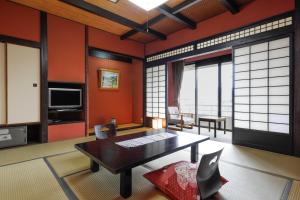 a living room with orange walls and a table at Yumenoi in Himeji