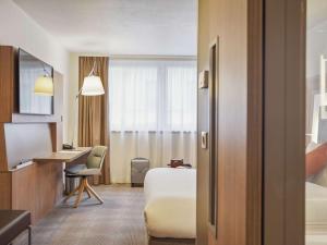 una camera d'albergo con letto e scrivania di Novotel Paris Gare De Lyon a Parigi
