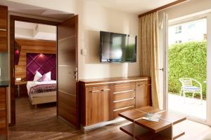 a living room with a tv and a bedroom at Arkona Strandresidenzen in Binz