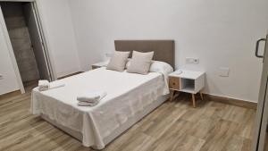 Habitación pequeña con cama y mesita de noche en Carmela estudio en Málaga