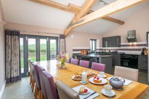 a kitchen and dining room with a wooden table and chairs at Brockram Barn in Kirkby Stephen