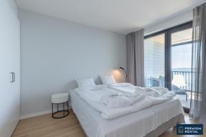 Cette chambre comprend un lit blanc et une grande fenêtre. dans l'établissement Singel suite Floor 3, à Hanko