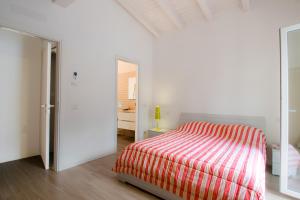 a bedroom with a bed with a red and white striped blanket at Green Woody Home in Rome