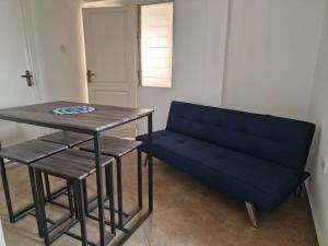 eine blaue Couch und ein Tisch in einem Zimmer in der Unterkunft Sigma Theta Homes - KNUST Area in Kumasi