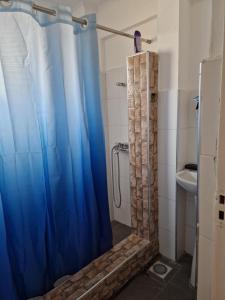 a bathroom with a shower with a blue shower curtain at Sigma Theta Homes - KNUST Area in Kumasi