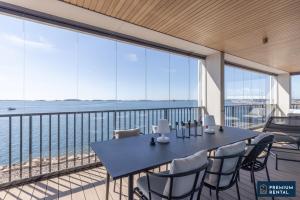 d'une table et de chaises sur un balcon avec vue sur l'océan. dans l'établissement Singel suite Floor 3, à Hanko