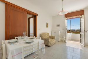a living room with a white table and a chair at Casa Solero by BarbarHouse in San Foca