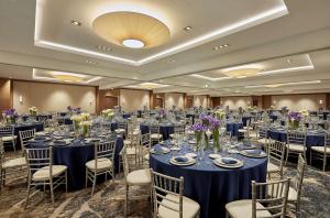 uma grande sala de banquetes com mesas e cadeiras azuis em Hyatt Regency John Wayne Airport Newport Beach em Newport Beach