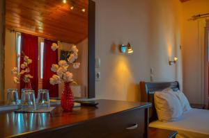 ein Zimmer mit einem Tisch mit einer Blumenvase darauf in der Unterkunft Ellas Hotel in Skala Potamias