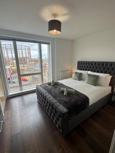 a bedroom with a large bed with a large window at Deluxe Shoreditch flat next to station with views in London