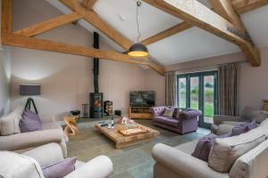 a living room with couches and a table at Brockram Barn in Kirkby Stephen