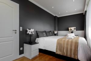 1 dormitorio con cama blanca y paredes negras en The Queen Luxury Apartments - Villa Fiorita, en Luxemburgo