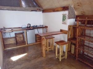 a kitchen with wooden tables and a counter in a room at Pongwe Eco Lodge and kitten paradise. in Mdudu Mdogo