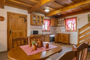 una cucina con tavolo in legno, tavolo e sedie di Vineyard Cottage Princess With Sauna - Happy Rentals a Mirna Peč