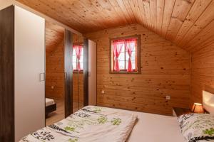 ein Schlafzimmer mit einem Bett in einem Holzzimmer in der Unterkunft Vineyard Cottage Princess With Sauna - Happy Rentals in Mirna Peč
