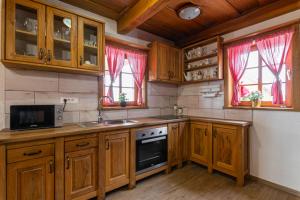 una cucina con armadi in legno e piano cottura di Vineyard Cottage Princess With Sauna - Happy Rentals a Mirna Peč