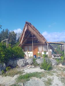 een klein huis met een rieten dak bij Pongwe Eco Lodge and kitten paradise. in Mdudu Mdogo