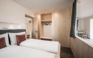 a bedroom with a white bed and wooden walls at Picea am Ötzerhof 2 in Merano