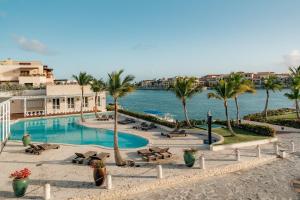 una piscina con palmeras y un cuerpo de agua en Sports Illustrated Resorts Marina and Villas Cap Cana - All-Inclusive en Punta Cana