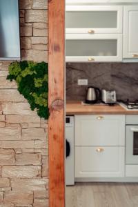 a kitchen with white cabinets and a brick wall at Exclusive Collection Palas Mall Suites and Studios in Iaşi