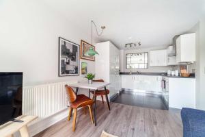 a kitchen and dining room with a table and chairs at Cosy East London Retreat in London