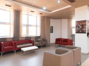 a waiting room with red chairs and a waiting table at Ibis Astana in Astana