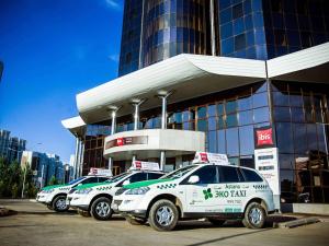 una fila di auto parcheggiate di fronte a un edificio di Ibis Astana a Astana