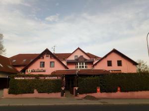a pink house with a hedge in front of it at Penzion u Martina in Liberec