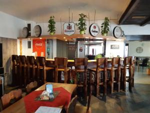 a restaurant with wooden chairs and a bar with clocks at Penzion u Martina in Liberec