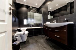 Baño en blanco y negro con lavabo y aseo en The Queen Luxury Apartments - Villa Fiorita, en Luxemburgo