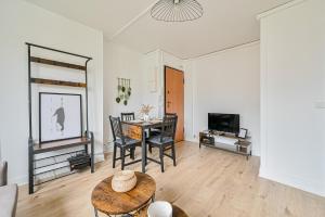 a living room with a table and a dining room at Le Coquet - 4 pers - Paris / La Défense - Parking in Courbevoie