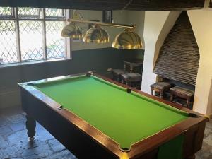 a pool table in a room with a green at Chequers Country Inn in Lutterworth