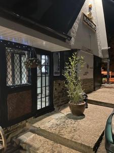 a front door of a building with a potted plant at Chequers Country Inn in Lutterworth