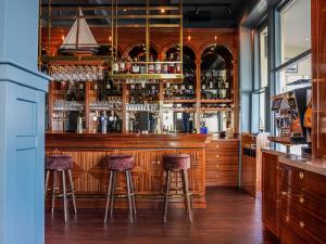 un bar con dos taburetes en una barra de madera en Boulevard Hotel Scheveningen, en Scheveningen