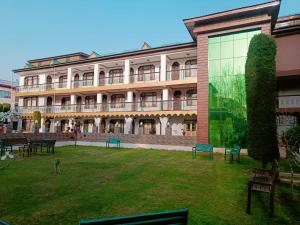 un grand bâtiment avec bancs devant lui dans l'établissement Hotel Kashmir Hilltown, Srinagar, à Moniawār