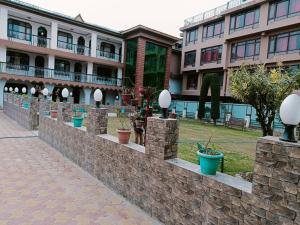 uma parede de pedra com vasos de plantas em frente a um edifício em Hotel Kashmir Hilltown, Srinagar em Moniawār