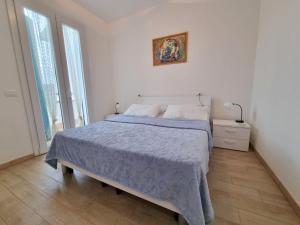 Dormitorio blanco con cama con edredón azul en Villa Demì, en Lido di Pomposa