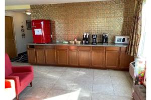 a kitchen with a counter and a red refrigerator at Columbus Motel in Columbus Junction