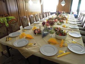 uma mesa longa com pratos e tigelas de comida em Ferienhaus am Netzener See em Nahmitz