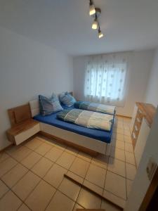 1 dormitorio con cama con sábanas azules y ventana en Widmanns Ferienquartier en Wiehl