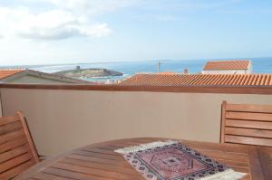 uma mesa e cadeiras numa varanda com vista para o oceano em Casa del Cisto em S'archittu Cuglieri